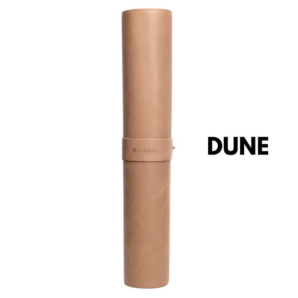 Rolled dune leather desk mat with strap embossed bullstrap; large text 'DUNE' to the right