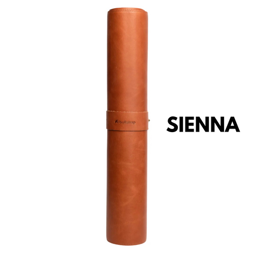 Rolled sienna leather desk mat with bullstrap logo and large SIENNA label at right.