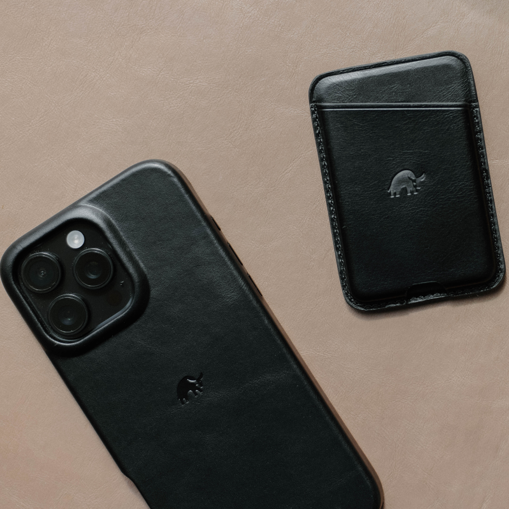 Black leather NavSafe wallet next to a black phone case, showcasing the wallet's design.