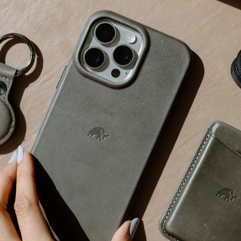 A hand holding the Flex Case in Slate color, showcasing its design and camera cutout.