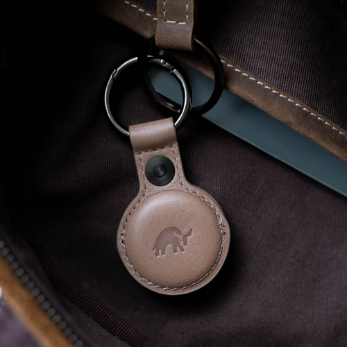 Leather BullTag for AirTag in Dune color, featuring a logo and keyring attachment.