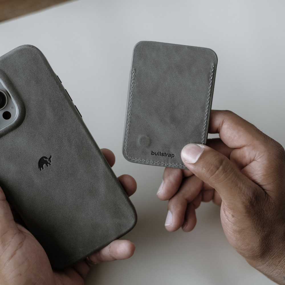 Slate leather NavSafe wallet held in hand with bullstrap logo visible