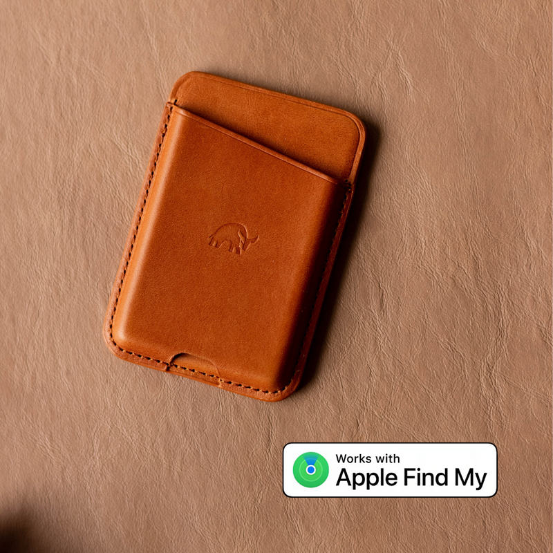 Tan leather card wallet with embossed rhino logo on textured leather; badge reads 'Works with Apple Find My'.