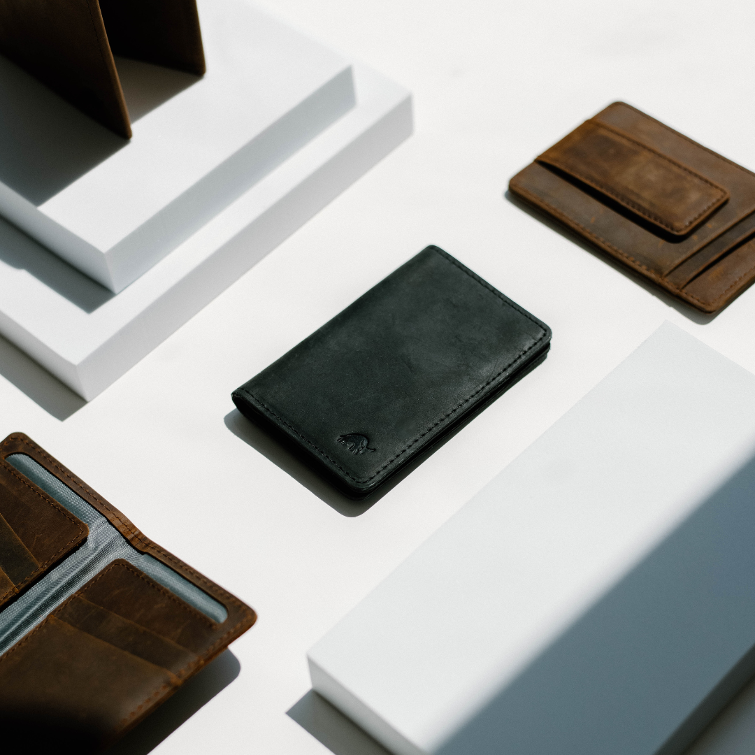 Black Messenger Wallet displayed among other wallets on a white surface