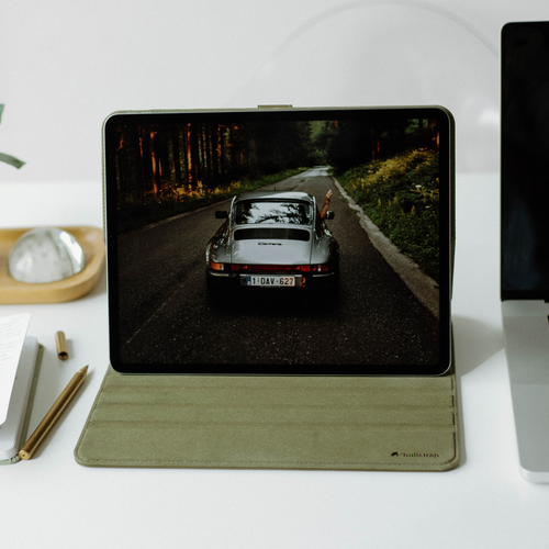 Leather iPad case displaying a car on the screen, placed on a desk.