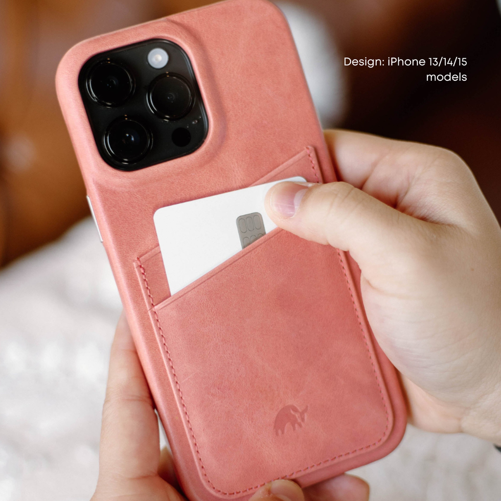 A person holding a pink leather iPhone case with a card in the slot.