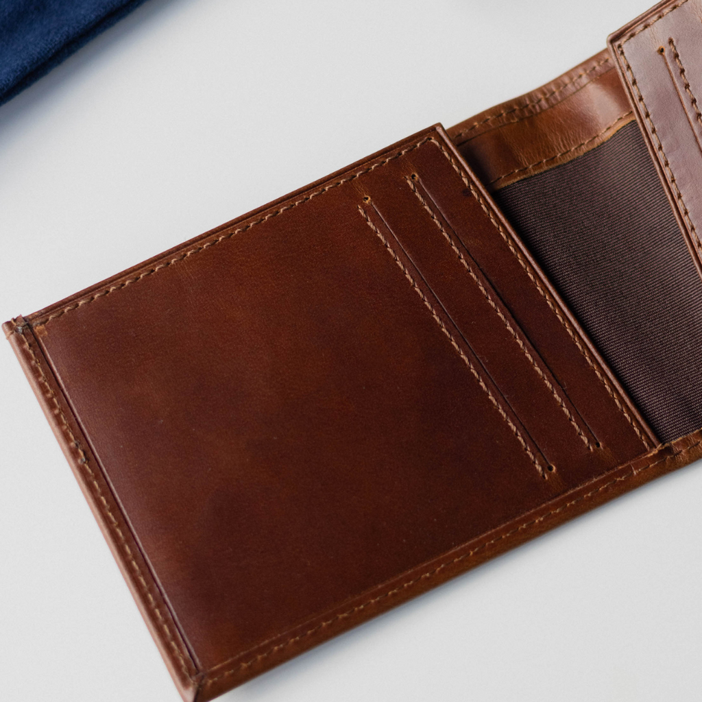 Open brown bifold wallet showing card slots and cash pocket