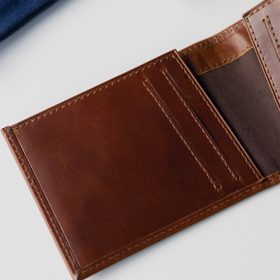 Open brown bifold wallet showing card slots and cash pocket