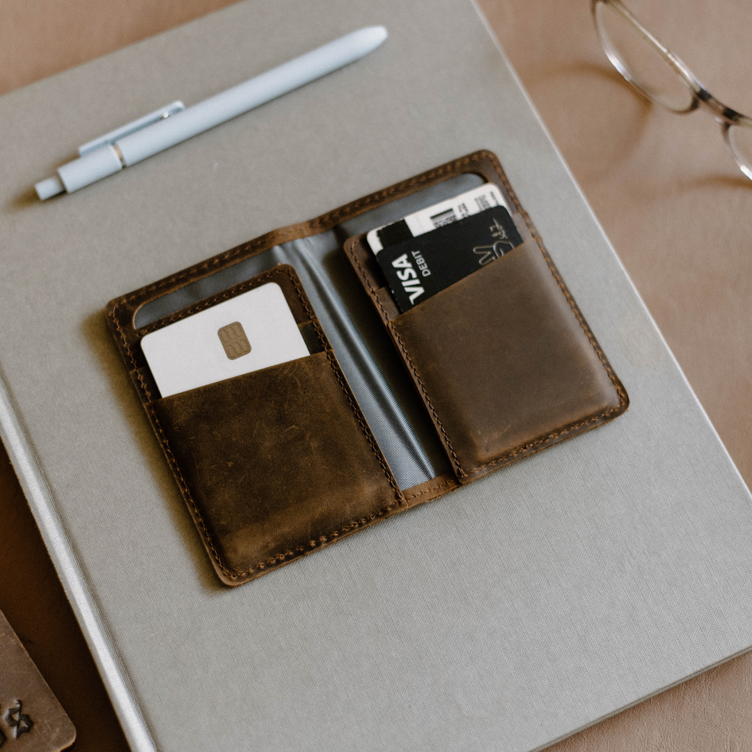 Terra colored leather wallet with two card slots and a grey notebook in the background