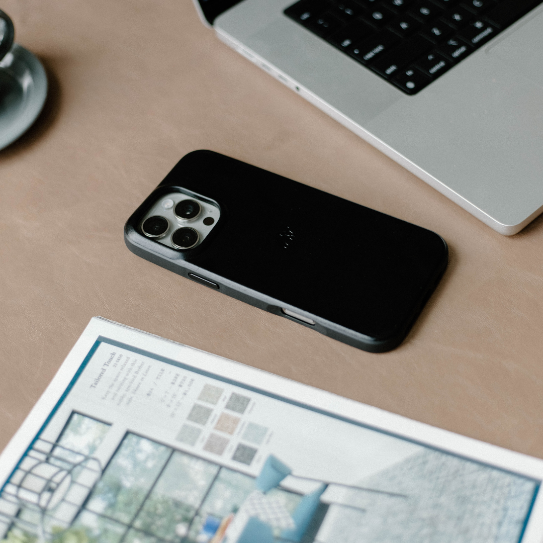 The Flex Case in Black Edition on a desk with a laptop and magazine
