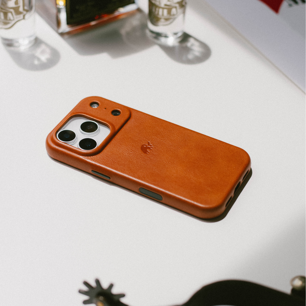 Sienna brown leather iPhone case lying face down, showing camera cutout and embossed logo