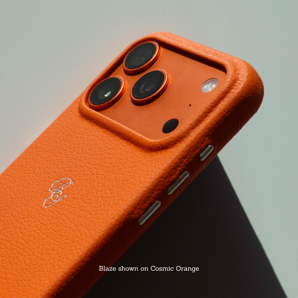 Angled back view of Performance Case Blaze in Cosmic Orange showing pebbled leather, raised camera bezel, and engraved Bullstrap logo