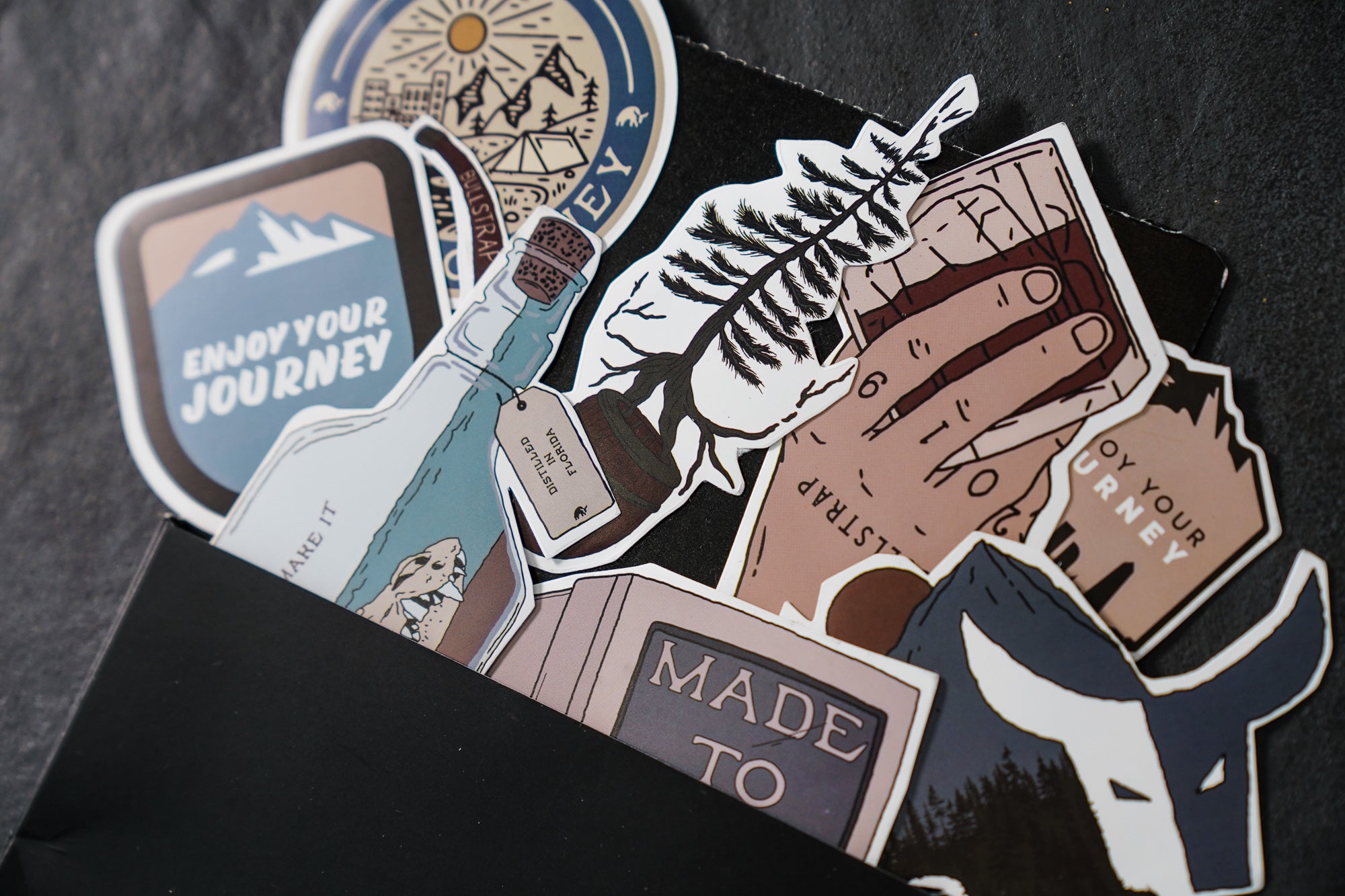 A collection of stickers featuring designs like 'Enjoy Your Journey' and 'Made To Stick'.