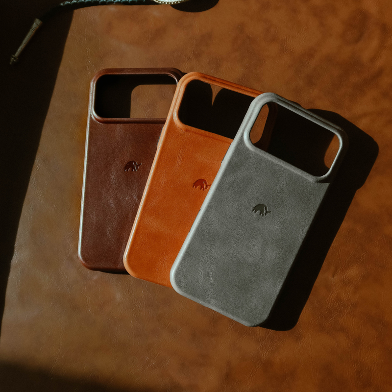 Three-quarter view of The Contemporary Plateau Case in sienna, chestnut, and gray showing leather texture and embossed logo