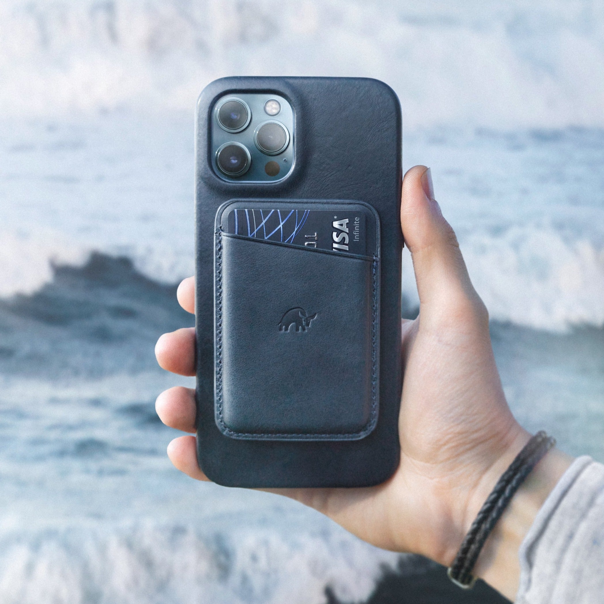 Leather magnetic card wallet attached to a phone case holding a card showing VISA Infinite