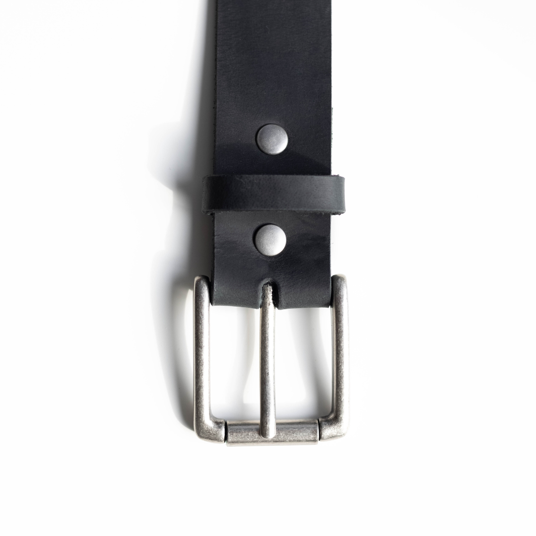 Close-up of a black leather belt with a silver buckle