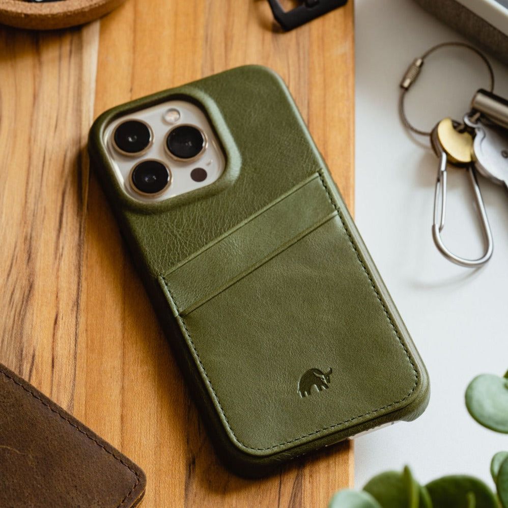 Olive-green leather iPhone case with two-card pocket, camera cutout, and small embossed rhino logo.