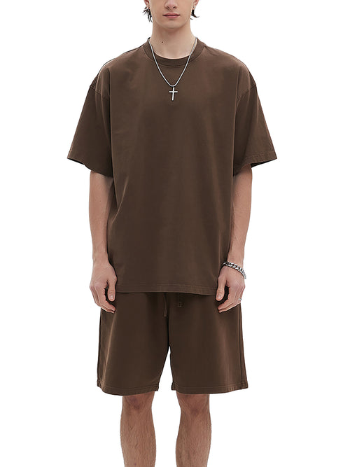 Model wearing oversized washed brown t-shirt with matching shorts and cross necklace, front view