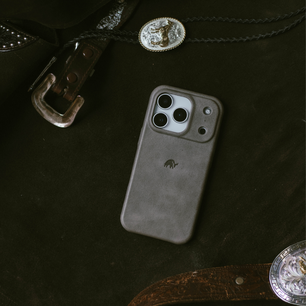 Slate leather phone case on dark fabric with leather belt and silver western conchos