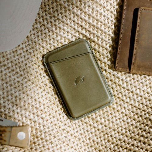 Green Maverick cardholder on a textured surface with a logo