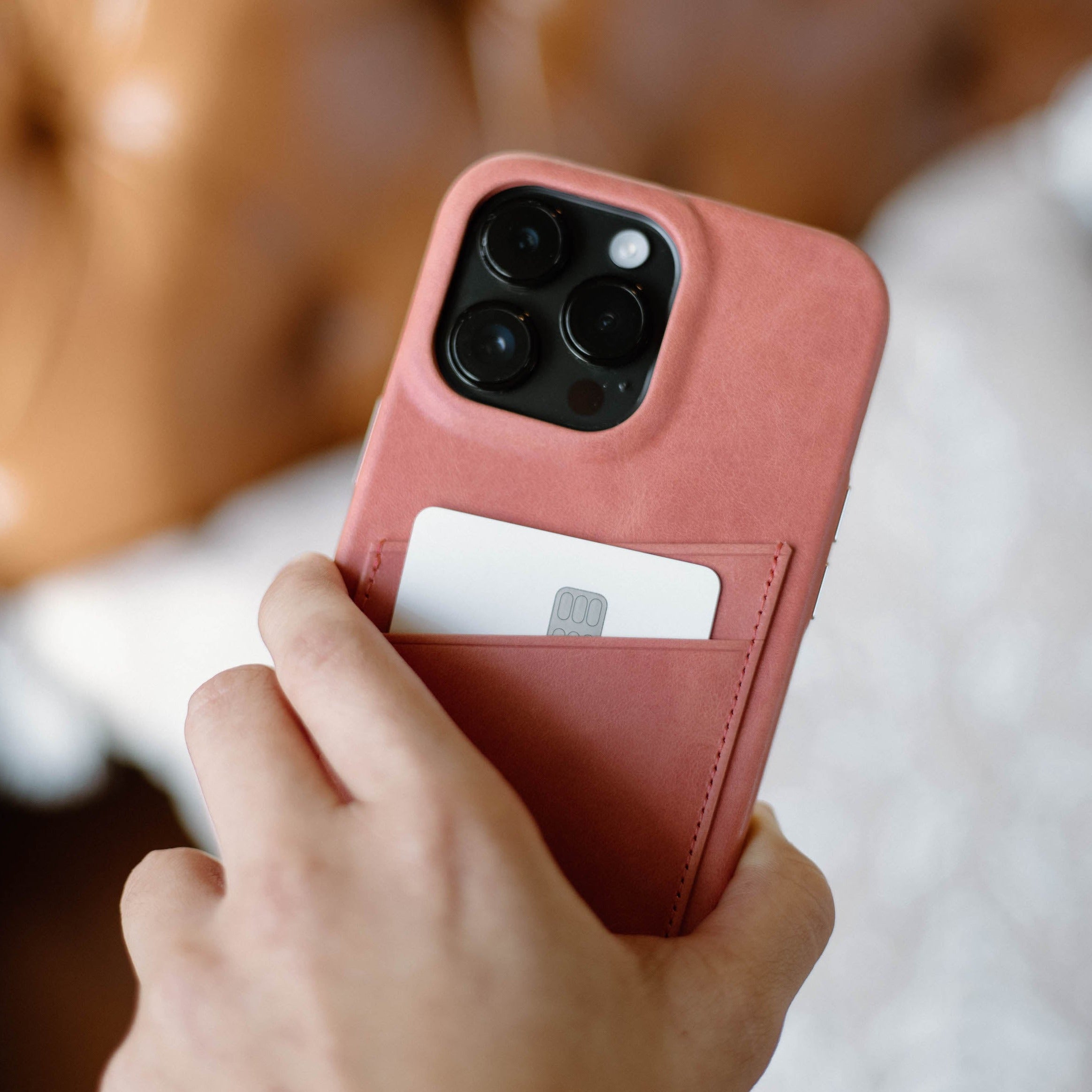 A hand holding a pink Minimalist Portfolio Case with a card slot, showcasing its design and functionality.