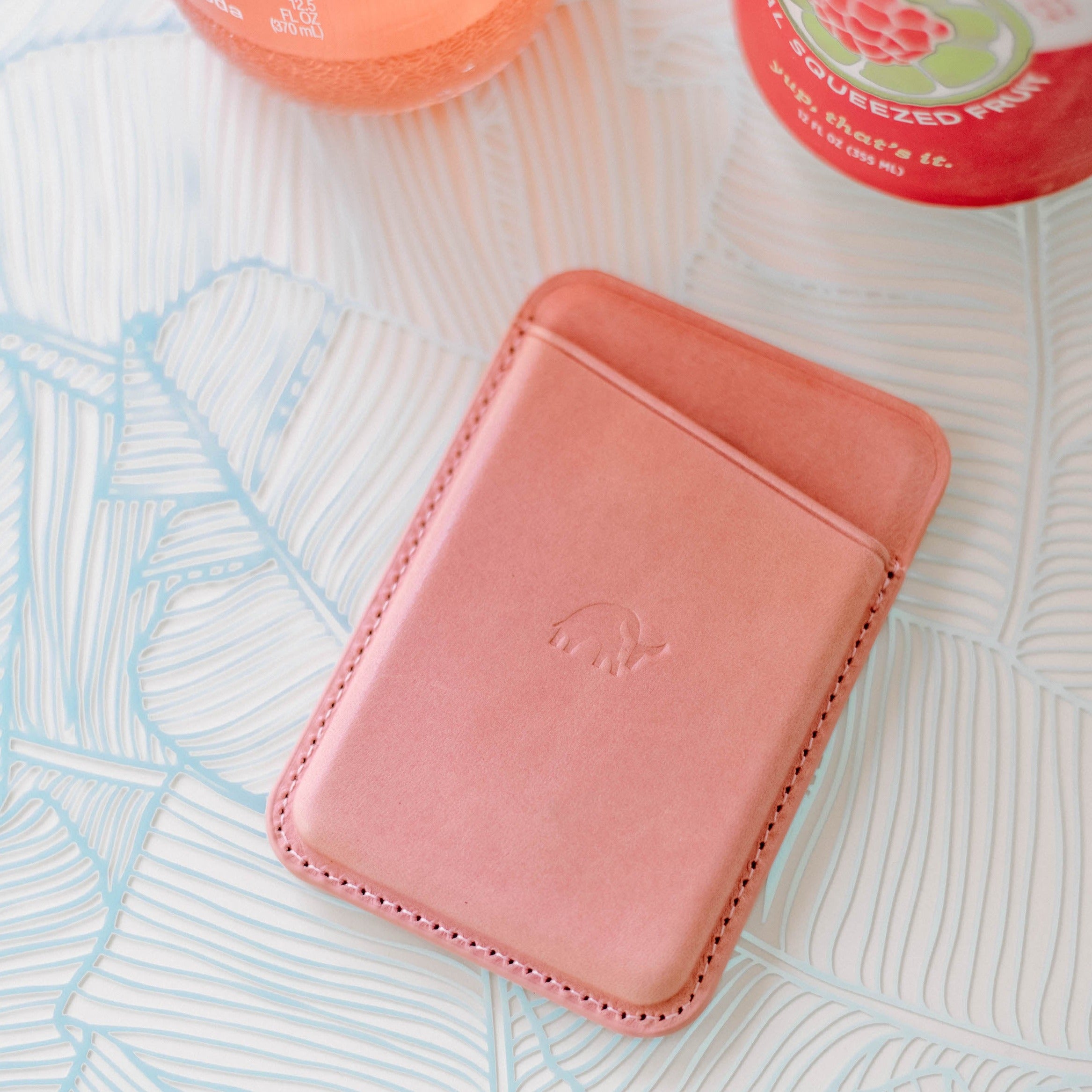 Pink leather magnetic wallet with embossed elephant logo on patterned surface; visible words: SQUEEZED FRUIT; yup, that's it.