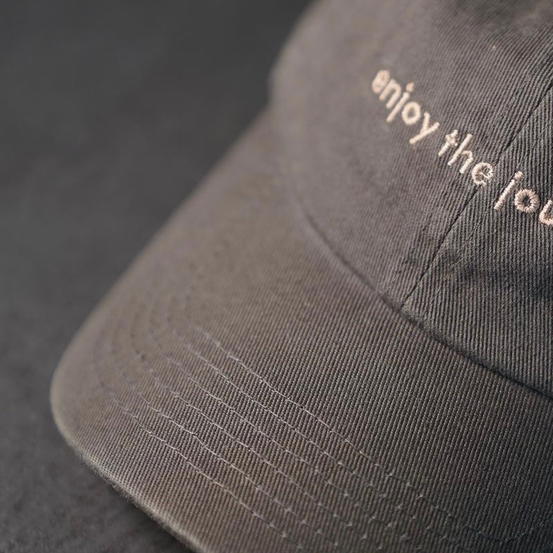 Journey Dad Hat in grey with 'enjoy the journey' embroidered on the front