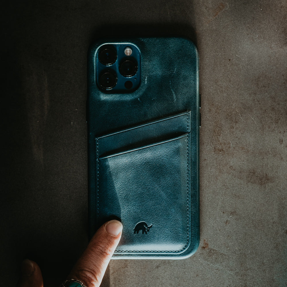 Teal leather phone wallet case with two card slots and embossed rhino logo; finger pressing lower pocket