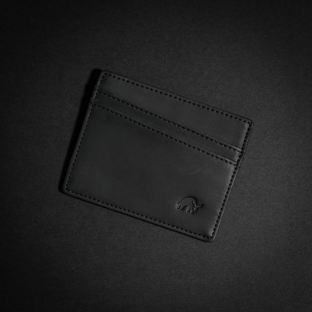 Black leather card holder with a logo on the front