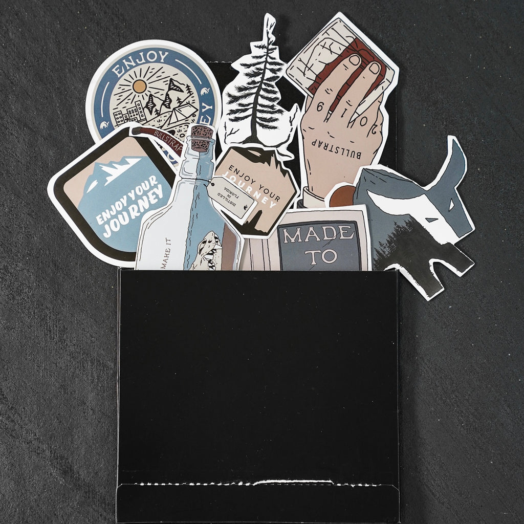 A collection of stickers including 'Enjoy Your Journey' and other designs, displayed in a black pocket.