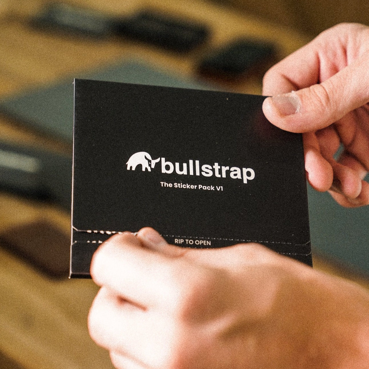 Black packaging of The Sticker Pack V1 with 'bullstrap' logo and 'RIP TO OPEN' text