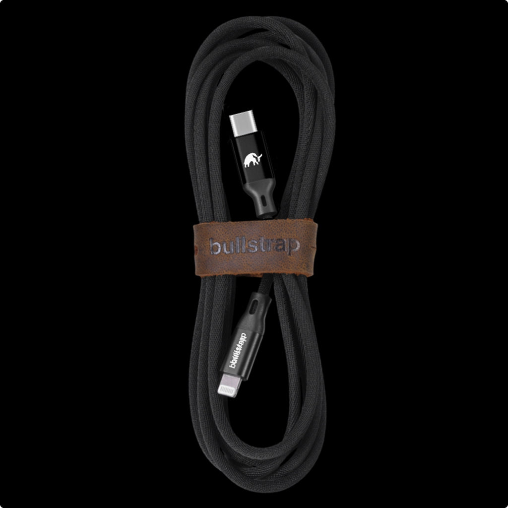 Black charging cable with USB-C and Lightning connectors, secured with a leather strap labeled 'bullstrap'.