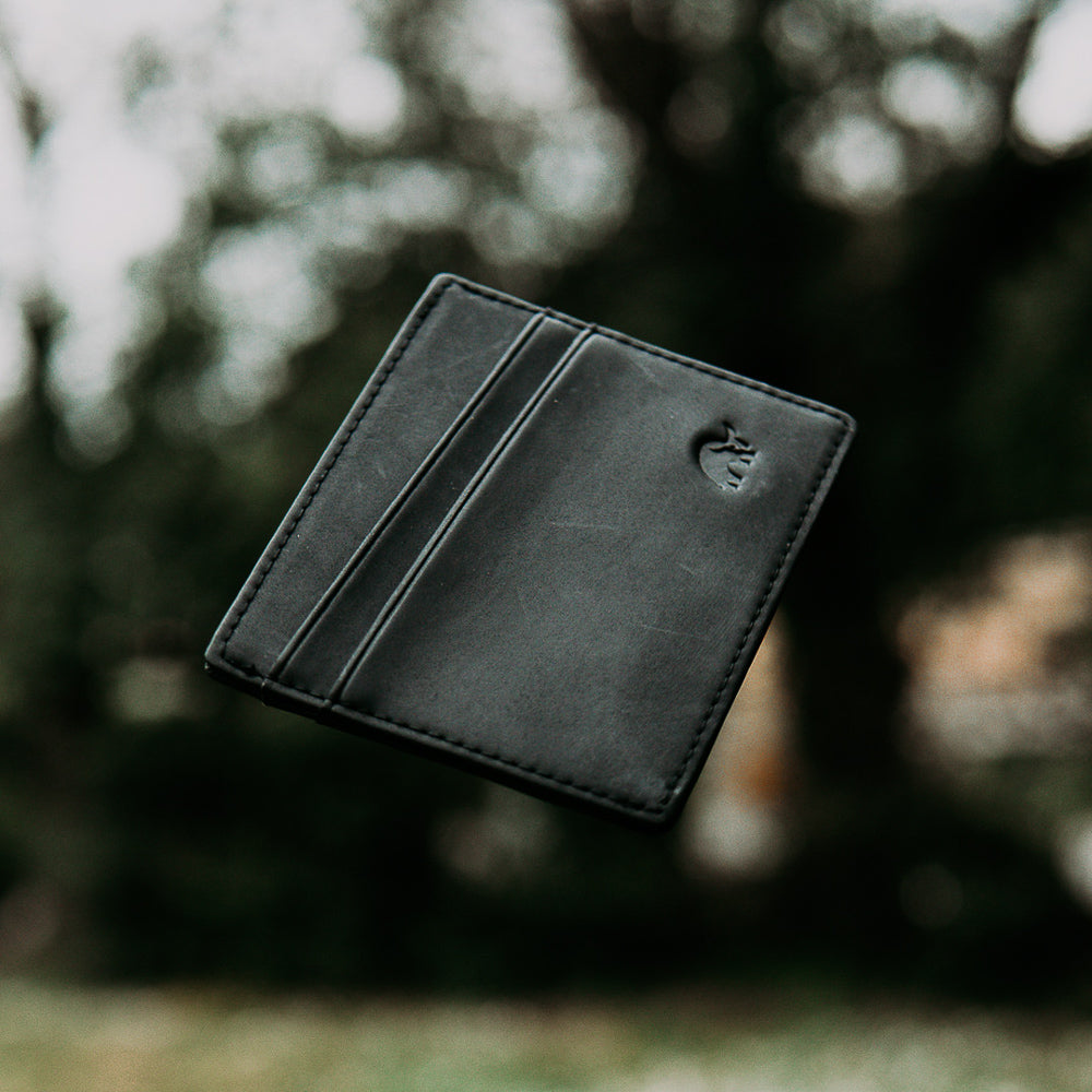 Black leather card holder with two card slots and embossed logo