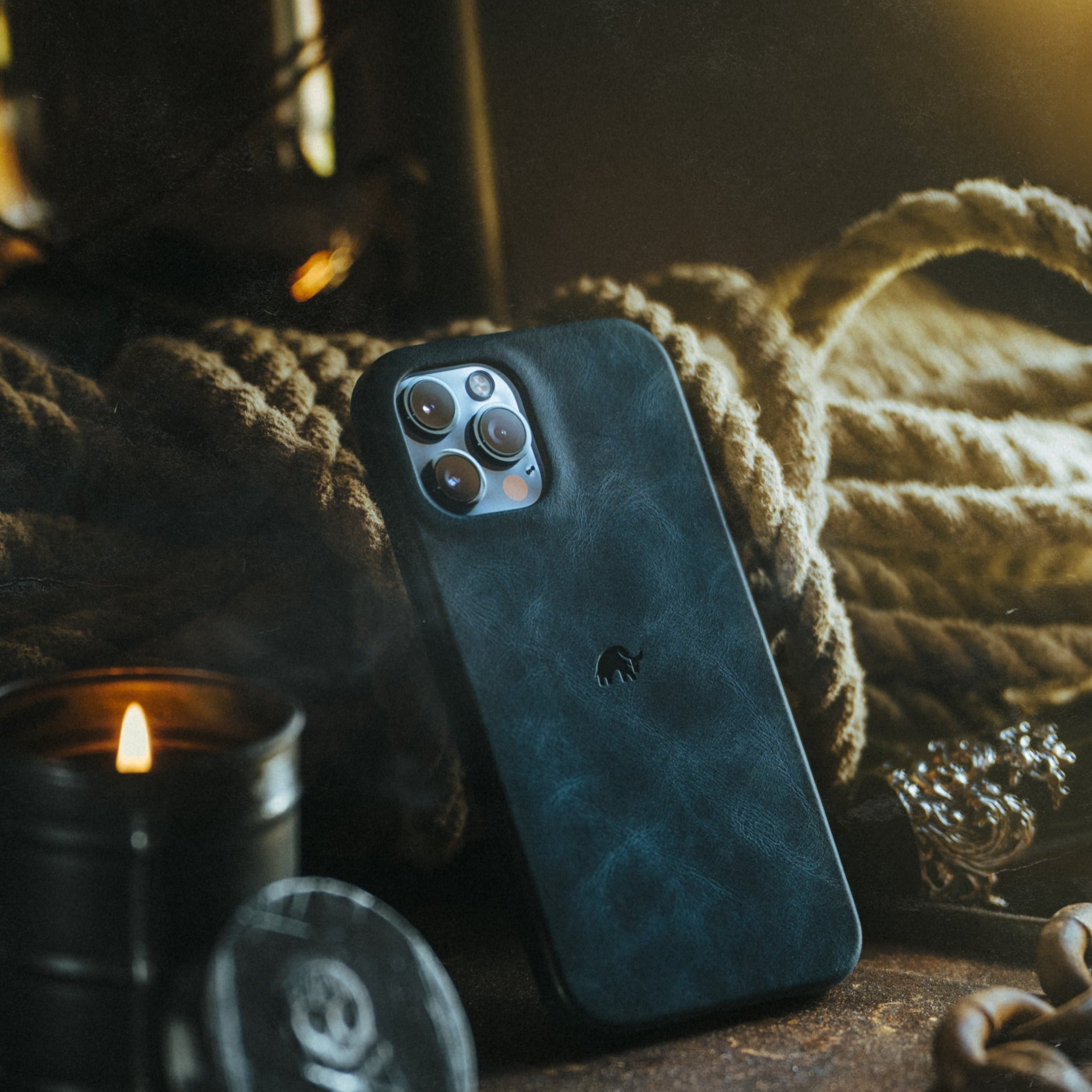 The Minimalist Case - OCEAN on a textured surface with a candle and rope in the background.
