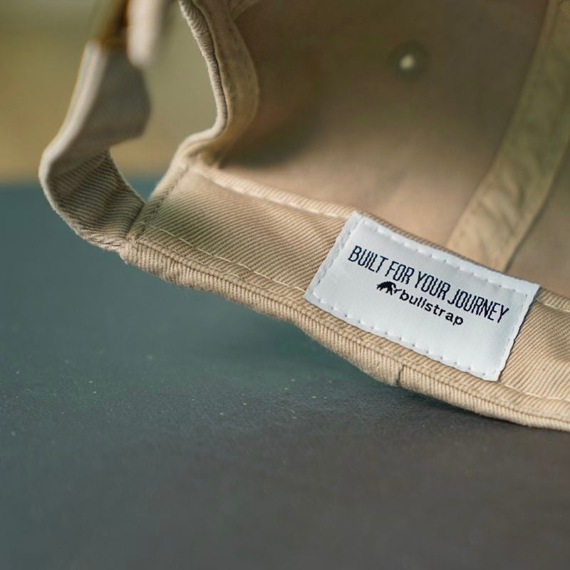 Tan cap interior with stitched white label reading BUILT FOR YOUR JOURNEY and bullstrap.