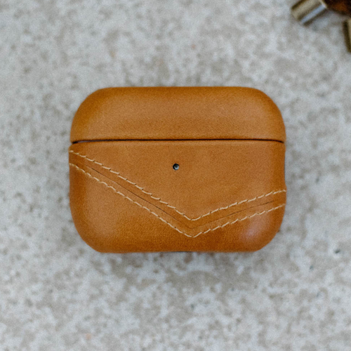 Top view of a leather AirPods case in sienna color with stitching detail.