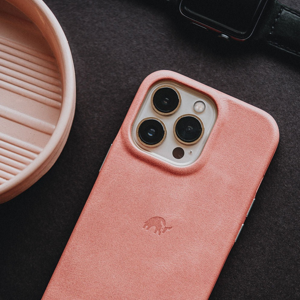 Pink leather iPhone case with raised triple-camera cutout and embossed elephant logo, South Beach
