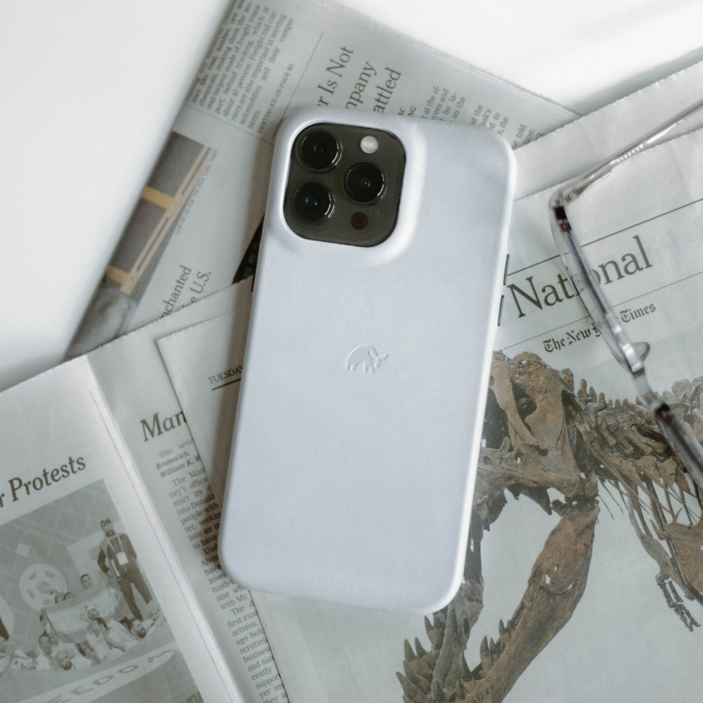 White iPhone with CLOUD case on folded newspapers with headlines National, The New York Times and Protests