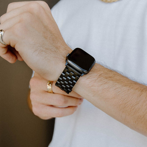 Black metal link band attached to an Apple Watch, shown on a wrist