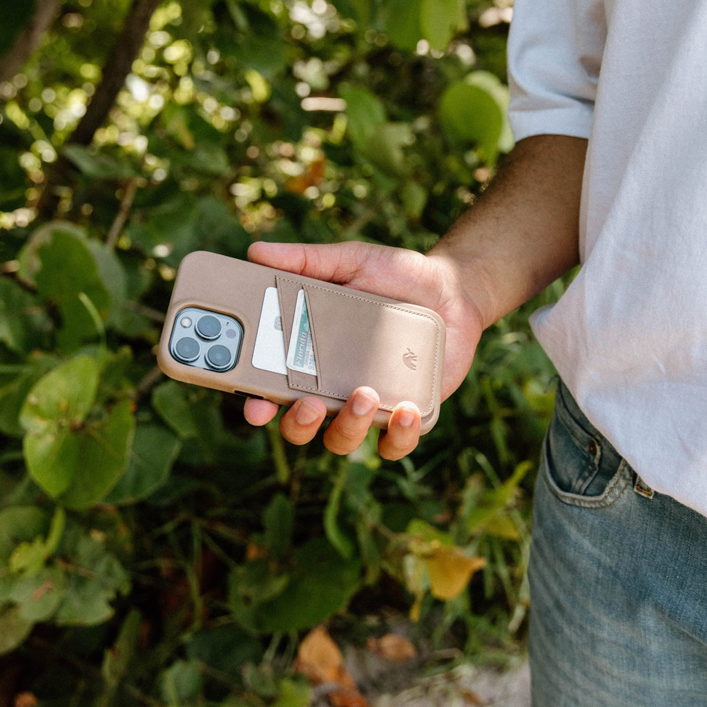 A person holding the Minimalist Portfolio Case in DUNE color with a card slot visible.
