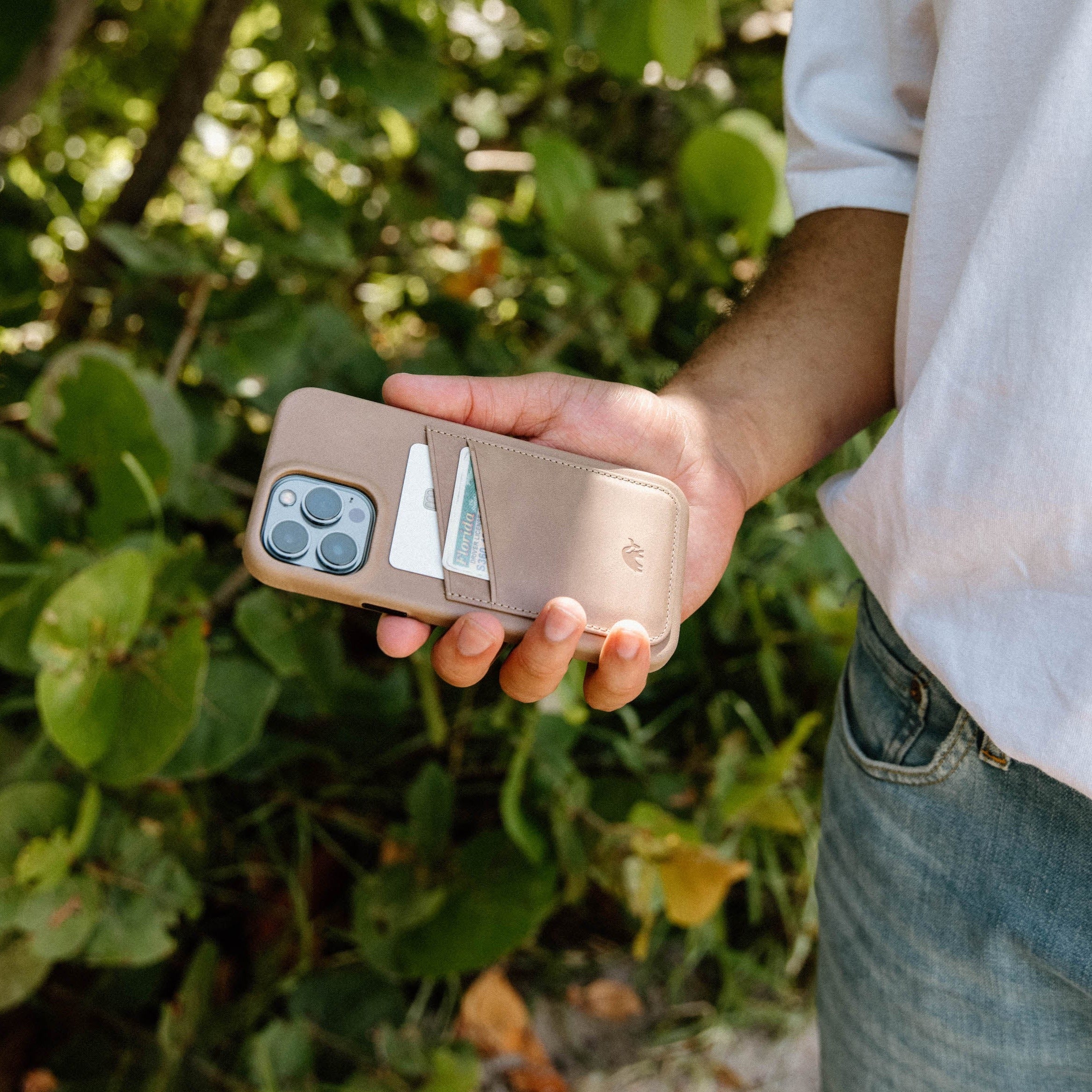 A person holding the Minimalist Portfolio Case in DUNE color with a card slot visible.