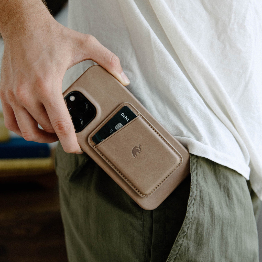 A person holding a minimalist phone case with a card slot, showcasing its design and functionality.